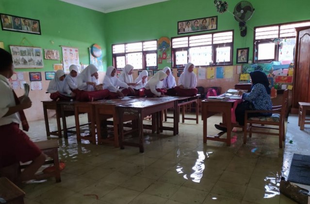 Tetap Semangat Walau Tergenang Banjir, Siswa di Sidoarjo Terpaksa Belajar di Atas Meja